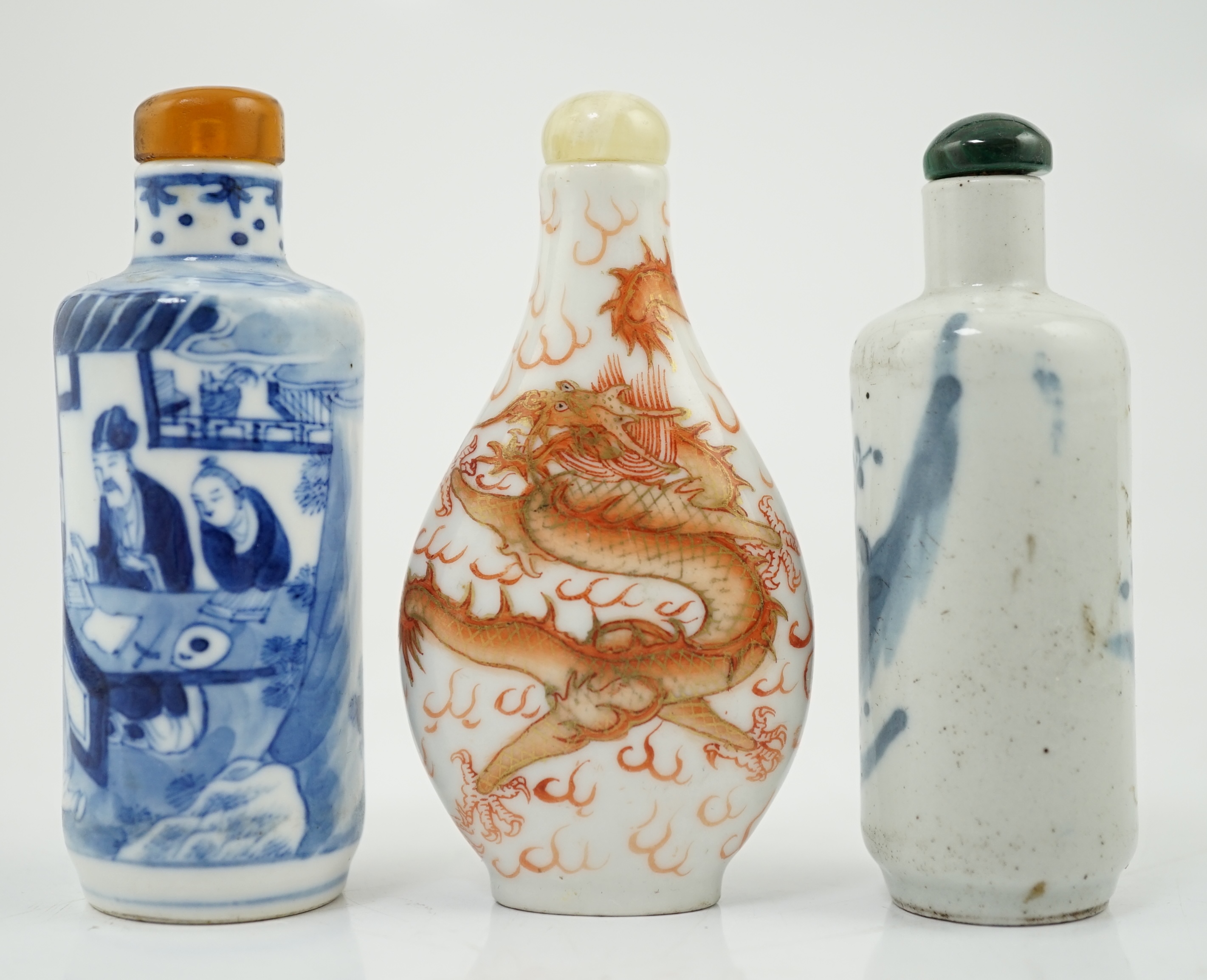 A Chinese iron red enamelled ‘dragon’ snuff bottle, Tongzhi mark and of the period (1862-74), together with two Chinese blue and white cylindrical snuff bottles, 19th century